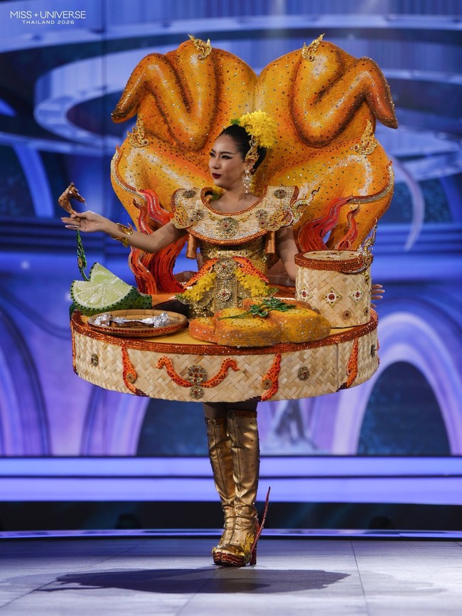 Sasiprapa Vitayatanagorn dari Provinsi Khon Kaen mengangkat makanan khas daerahnya dalam kostum nasional Miss Universe Thailand 2026. Khon Kaen dikenal dengan ayam panggangnya, sehingga Sasiprapa tampil dengan kostum yang terinspirasi dari hidangan tersebut. Ia bahkan membawa potongan ayam panggang sungguhan sebagai pelengkap penampilannya. Foto: Dok. Facebook Miss Universe Thailand