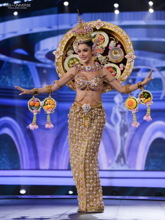 Tharina Botes yang mewakili wilayah Bangkok di Miss Universe Thailand 2026 menghadirkan kostum yang merepresentasikan hidangan khas Thailand. Busananya menggambarkan perpaduan cita rasa khas kuliner Thailand, mulai dari manis, asam, asin hingga pedas. Kostum Tharina sekilas seperti sepiring nasi dengan berbagai lauk dalam versi yang lebih glamor. Foto: Dok. Facebook Miss Universe Thailand