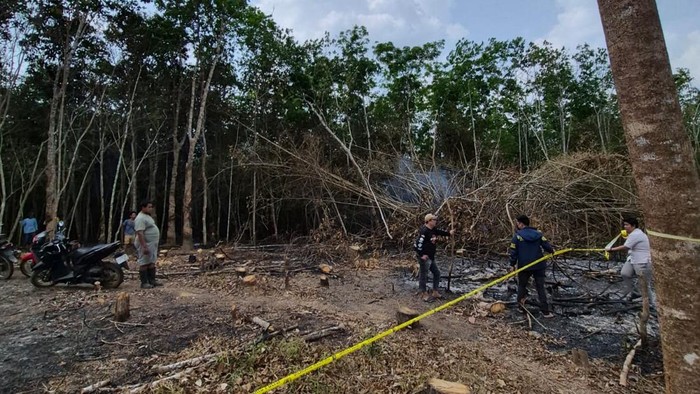 Petugas memasang garis polisi di lokasi lahan yang terbakar di Banyuasin