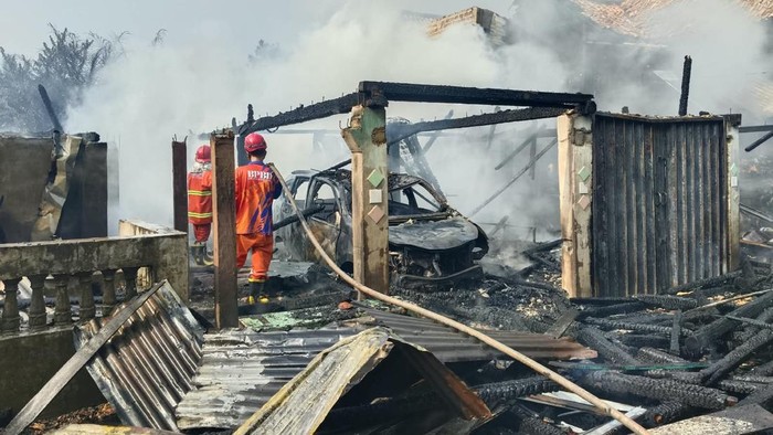 Petugas saat memadamkan kebakaran rumah  di Muratara