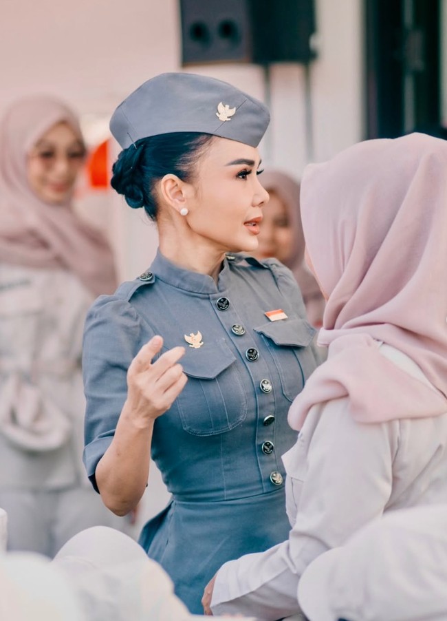Penampilan Yuni lengkap dengan topi model field cap berwarna abu-abu yang senada. Sementara rambut hitamnya ditata disanggul rendah dan sleek, sehingga terlihat rapi dan tidak mengganggu tampilan formalnya. Foto: Instagram/@yunishara36