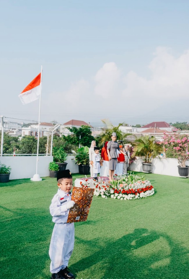 Yuni menjadi inspektur upacara, memandu jalannya pengibaran bendera merah-putih untuk murid-murid PAUD di sekolah miliknya, PAUD Cahaya Permata Abadi. Foto: Instagram/@yunishara36