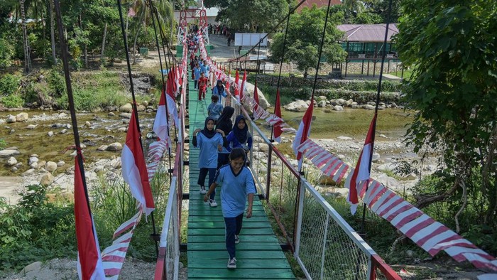 Sejumlah anak berjalan di atas Jembatan Garuda yang dibangun Kodam XXIII Palaka Wira di Desa Nambaru, Kabupaten Parigi Moutong, Sulawesi Tengah, Jumat (21/8/2026). Kodam XXIII Palaka Wira membangun 106 Jembatan Garuda terdiri dari 53 unit di Sulawesi Tengah  dan 53 unit di Sulawesi Barat untuk menghubungkan antardesa dan  mempermudah akses warga menuju lahan pertanian. ANTARA FOTO/Muhammad Rifki Hasan