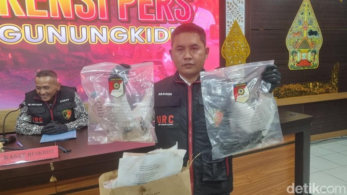 Polisi saat menunjukkan barang bukti berupa dua botol air mineral kemasan isi sisa solar.