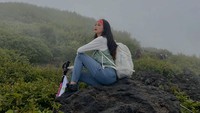 Desy Genoveva berpose di atas batu dengan cuaca berkabut di sekitarnya. 9Foto: dok Instagram desygenoveva_)