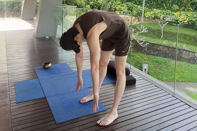 Meski sedang liburan, Lee Jong Suk tetap menjaga rutinitas olahraganya. Ia melakukan peregangan badan beralaskan matras di balkon penginapannya. Foto: dok. Instagram @jongsuk0206