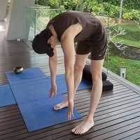 Meski sedang liburan, Lee Jong Suk tetap menjaga rutinitas olahraganya. Ia melakukan peregangan badan beralaskan matras di balkon penginapannya. Foto: dok. Instagram @jongsuk0206