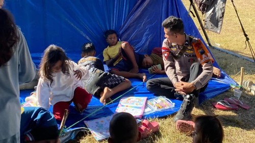 Salah satu personel Satbrimob Polda Jatim trauma healing anak-anak korban gempa di NTT. (Dok. Polda Jatim)