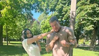 Agnez Mo tampil energik saat berpose mengepalkan tinju bersama bintang utama Reacher, Alan Ritchson. Keduanya tampak santai namun tetap menunjukkan aura laga di area outdoor lokasi syuting. (Foto: Instagram @agnezmo)