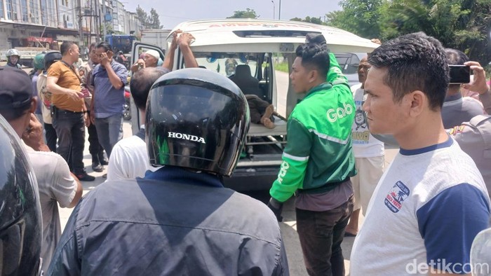 Penumpang ojol yang meninggal dunia di Jalan Haji Anif di Kecamatan Percut Sei Tuan, Deli Serdang, saat dievakuasi ke ambulans.
