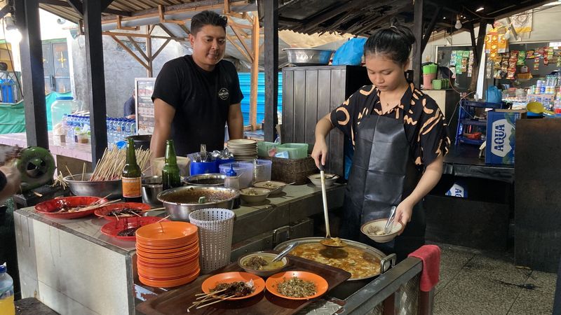 Proses penghidangan menu Sate Kambing Ibu Safiah di Pasar Senggol, Semarapura, Klungkung, Bali, Sabtu (22/8/2026). (Fatih Kudus Jaelani/detikBali)