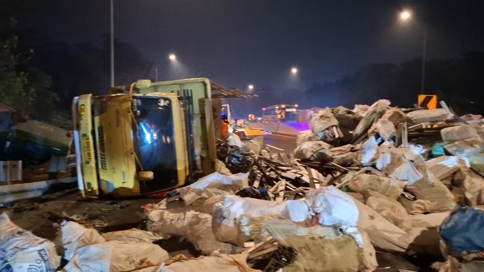 Truk muatan rongsokan terguling usai tabrakan di Tol Cipularang.