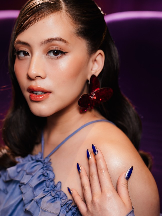 Untuk aksesori, ia mengenakan anting besar berbentuk kupu-kupu berwarna merah burgundy, yang menjadi aksen warna cukup kuat di antara dominasi biru muda dan hitam. Foto: Instagram/@zaraadhsty @@armanfebryan
