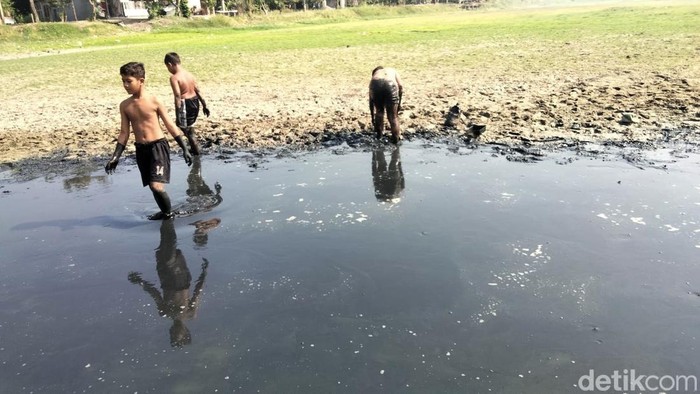 Anak-anak sedang bermain di waduk Desa Tenaru, Gresik yang mulai mengering