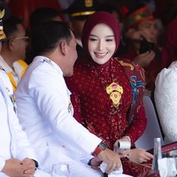 Gaya formal Thisia terlihat dari pilihan kebaya brokat panjang berwarna merah marun dengan aksen payet keemasan di bagian dada. Penampilannya disempurnakan dengan selempang kain batik panjang bermotif klasik yang anggun. Foto: Dok. Instagram @thisia.halijam.