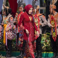 Aisyah Thisia memadukan kebaya brokat merah marun berpayet mewah dengan hijab segi empat warna senada yang ditata rapi. Penampilannya dilengkapi aksesori selendang batik berpola khas serta gelang emas. Foto: Dok. Instagram @hisia.halijam.