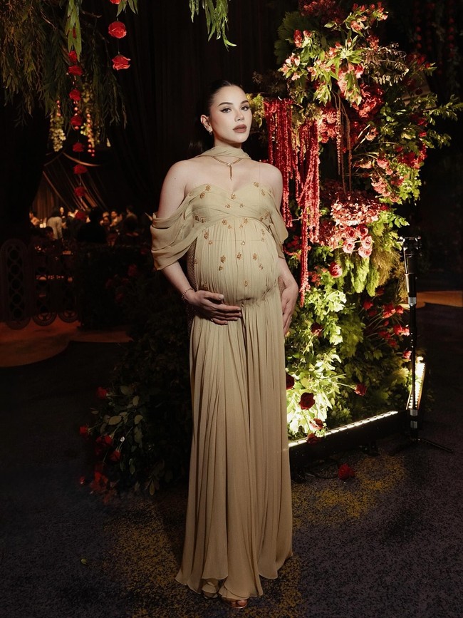 Jika ingin gaya yang elegan dan berkelas saat sedang hamil, mungkin bisa meniru gaya kondangan Alyssa Daguise. Pilihan gaun off shoulder berbahan tulle dengan detail yang minimalis dan aksen lekuk membentuk perut membuat penampilan terlihat stunning. Foto: Dok. Instagram