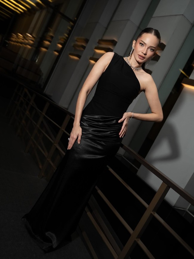 Kemudian ada inspirasi baju kondangan dari Enzy Storia. Gaun one shoulder warna hitam pekat dilengkapi kalung dan anting panjang sudah membuat penampilan terlihat elegan serta berkelas. Foto: Dok. Instagram