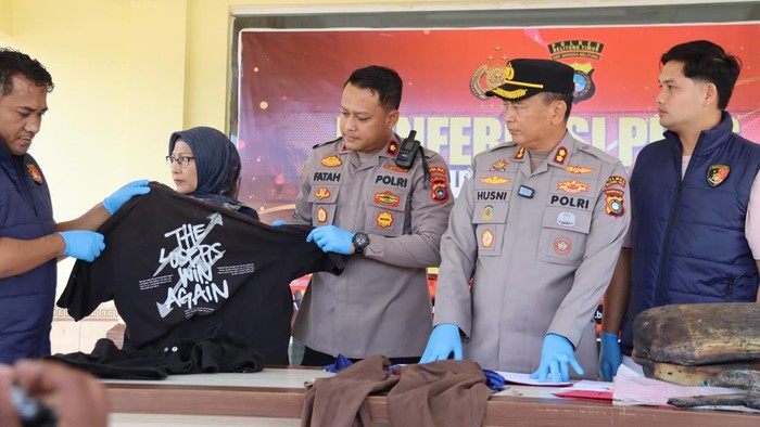 Polisi menunjukkan baju yang digunakan seorang pelaku saat pembakaran lahan.