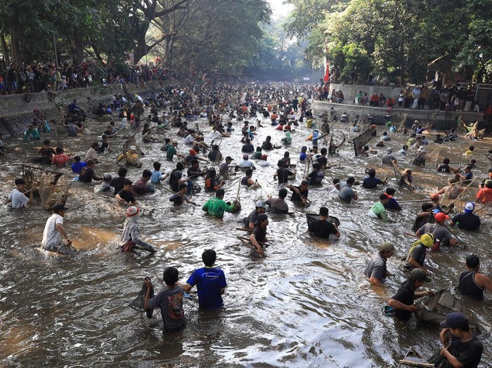 Sejumlah warga menangkap ikan saat tradisi Grobyak Ikan di Sumber Gundi, Kabupaten Kediri, Jawa Timur, Minggu (23/8/2026). Tradisi memanen ikan hanya sekali dalam setahun tersebut merupakan cara warga sekitar mensyukuri aliran mata air yang tidak pernah mengering sekaligus menjaga ekosistem agar tetap lestari. ANTARA FOTO/Prasetia Fauzani/wsj.