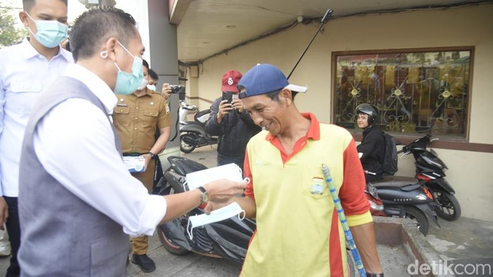 Ratu Dewa membagikan masker ke petugas kebersihan.