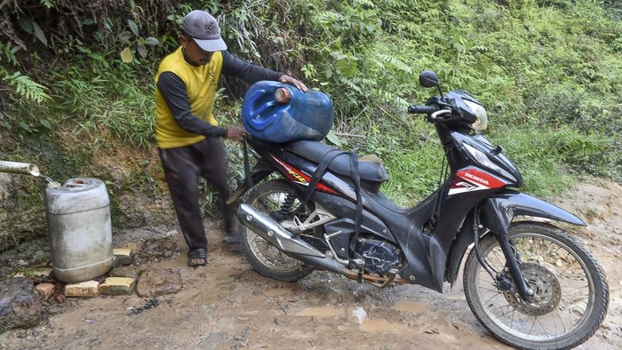 Warga mengikat jeriken berisi air yang ditampung dari mata air di kebun kelapa sawit Desa Danau Embat, Batang Hari, Jambi, Senin (24/8/2026). Warga Desa Danau Embat dan Terusan memanfaatkan mata air tersebut untuk kebutuhan minum dan mencuci setelah air sumur mulai mengering akibat kemarau dalam tiga minggu terakhir. ANTARA FOTO/Wahdi Septiawan