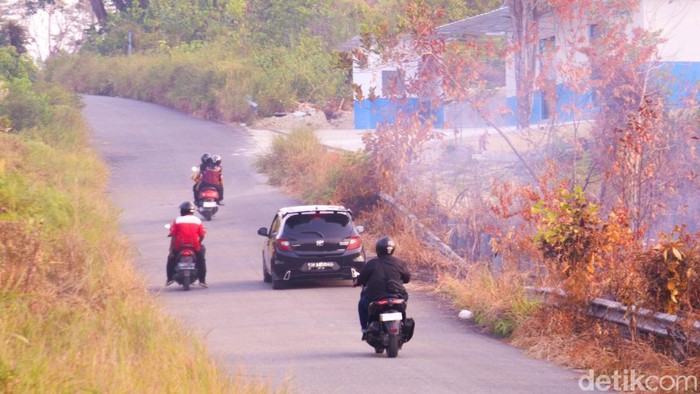Pengendara roda empat melintas di Jalan Amal Lama, Tarakan Timur yang diselimuti asap kebakaran lahan. (Oktavian Balang/detikKalimantan)