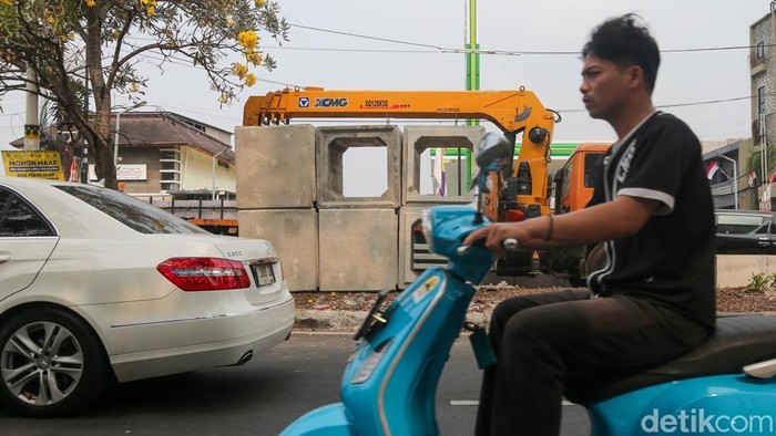 Pengguna jalan melintasi proyek saluran air dengan metode jacking di Jalan Karang Tengah Raya, Lebak Bulus, Jakarta Selatan, Senin (24/8/2026). Pemerintah Kota (Pemkot) Jakarta Selatan melalui Suku Dinas Sumber Daya Air (SDA) menargetkan proyek ini rampung Desember mendatang.