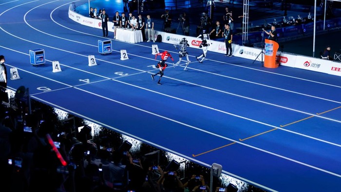 BEIJING, CHINA - AUGUST 22: Humanoid robots compete in the 100-meter preliminary race ahead of the opening ceremony of the 2nd World Humanoid Robot Games at the National Speed Skating Oval on August 22, 2026 in Beijing, China. (Photo by Han Haidan/Ch