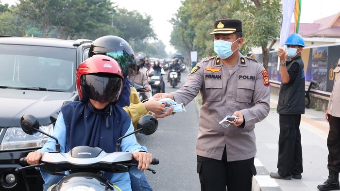 Polda Riau turun membagikan ribuan masker untuk mencegah paparan asap karhutla di Kota Pekanbaru, Selasa (25/8/2026).