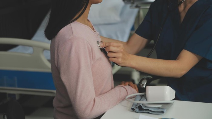 Doctor and patient discussing something while sitting at the table . Medicine and health care concept. Doctor and patient