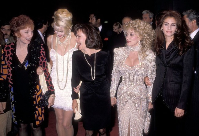 Pada 1989, Dolly Parton yang terkenal lewat tembang seperti 9 to 5, Jolene, dan I Will Always Love You kembali lagi bemain film, kali ini bersama Sally Field dan Julia Roberts. Saat menghadiri pemutaran perdana film bertajuk Steel Magnolias itu,  Dolly memakai gaun penuh detail berkilauan.   (Foto: Ron Galella Collection via Getty/Ron Galella, Ltd.)