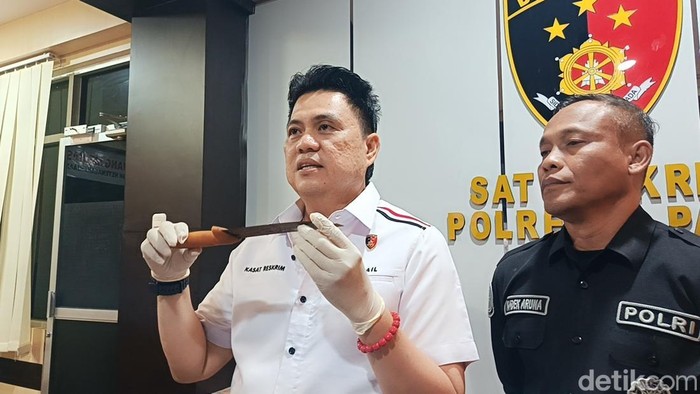 Kasatreskrim Polresta Palu, AKP Ismail Boby (kiri) saat memegang barang bukti pembunuhan satu keluarga di Palu.