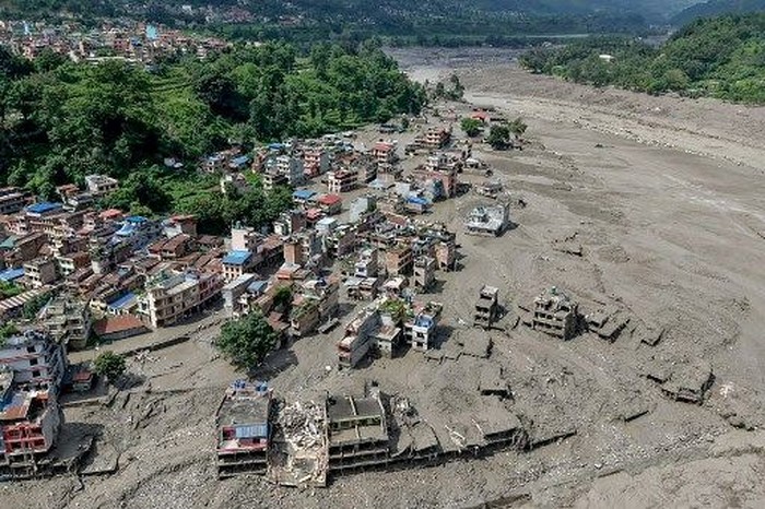 Houses lie partially submerged in muddy water along a riverside after flash floods at Trishuli Bazar in Nepals Nuwakot district on August 26, 2026. A massive flood swept through Nepals northern Rasuwa district on August 26, damaging roads and power infrastructure as authorities scrambled to assess the scale of the destruction. (Photo by Prabin RANABHAT / AFP)