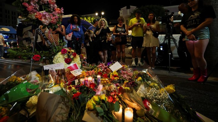 Dominique Nisperos and Lucy Sartor sing Dolly Parton songs at her star on the Hollywood Walk of Fame, as people gather near the star after it was announced that the country music icon died aged 80, in Los Angeles, California, U.S., August 25, 2026. REUTERS/Mario Anzuoni