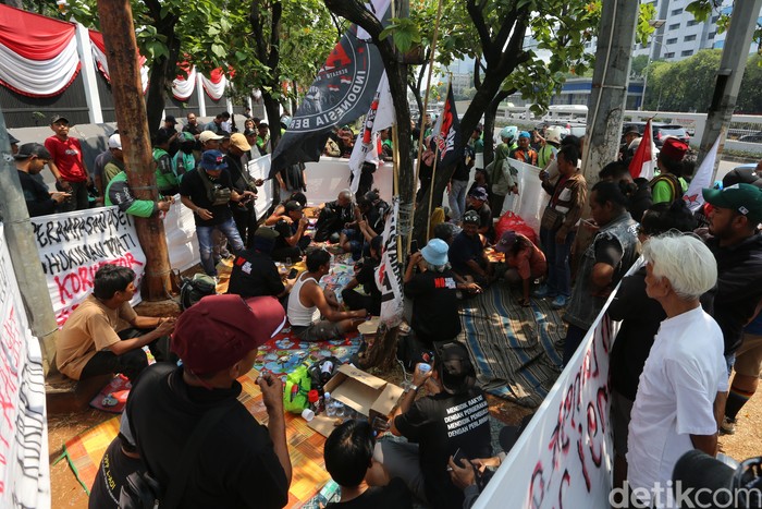 Massa dari Aliansi Masyarakat Pati Bersatu (AMPB) yang berencana menggelar aksi damai besok mendirikan posko di depan gedung DPR, Jl Gatot Subroto, Jakarta, Rabu (27/8/2026). Mereka berkumpul, duduk-duduk, membuat spanduk tuntutan dari cat semprot hingga pengumpulan donasi dan menjual kaos. Tampak sumbangan makanan dan minuman dari warga terus berdatangan untuk mendukung aksi damai besok dengan berbagai tuntutan seperti mensahkan RUU Perampasan Aset hingga hukuman mati untuk koruptor.