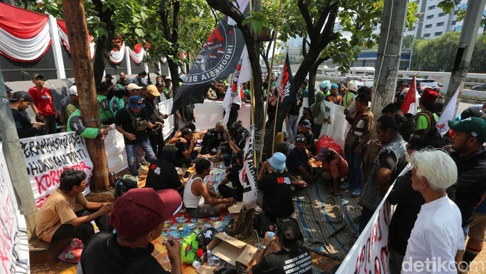Massa dari Aliansi Masyarakat Pati Bersatu (AMPB) yang berencana menggelar aksi damai besok mendirikan posko di depan gedung DPR, Jl Gatot Subroto, Jakarta, Rabu (27/8/2026). Mereka berkumpul, duduk-duduk, membuat spanduk tuntutan dari cat semprot hingga pengumpulan donasi dan menjual kaos. Tampak sumbangan makanan dan minuman dari warga terus berdatangan untuk mendukung aksi damai besok dengan berbagai tuntutan seperti mensahkan RUU Perampasan Aset hingga hukuman mati untuk koruptor.