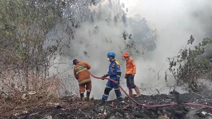 Petugas memadamkan api di TPA Cioray Tasikmalaya.