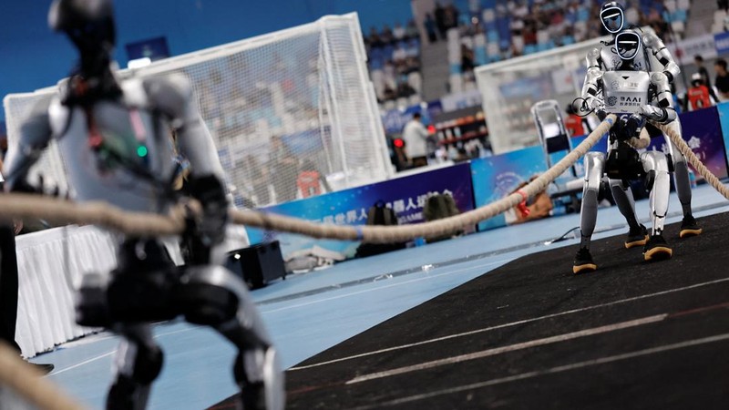 Humanoid robots by Yobotics compete in a tug-of-war contest during the 2026 World Humanoid Robot Games at the National Speed Skating Oval in Beijing, China, August 25, 2026. REUTERS/Tingshu Wang