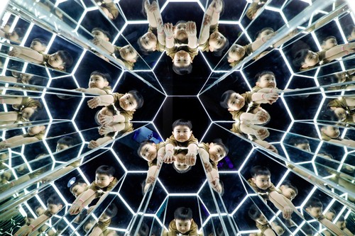 Boys play inside a space-themed immersive digital art installation 