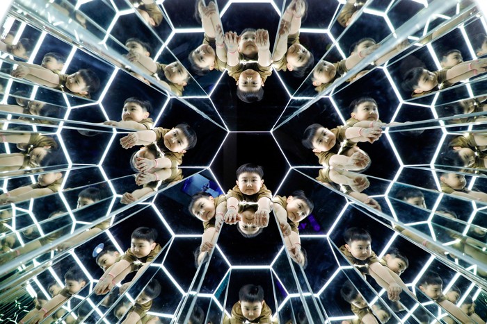 Boys play inside a space-themed immersive digital art installation 