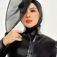 Salah satu elemen paling mencuri perhatian adalah headpiece hitam berukuran cukup besar karya Rinaldy Yunardi. Bentuknya menyerupai topi dengan lembaran transparan berwarna smoky gray yang menjulang ke atas dan melebar ke samping. Foto: Instagram/@princessyahrini