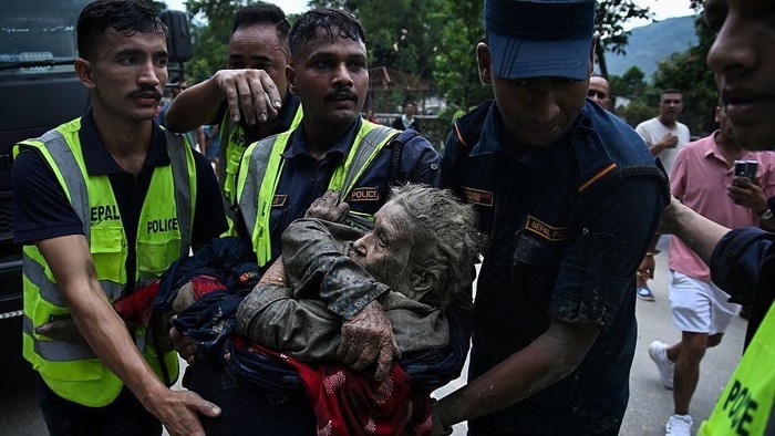 Seorang warga yang terdampak banjir bandang di Devghat, Distrik Nuwakot, Nepal, dievakuasi tim penyelamat, Rabu (26/08). (EPA)