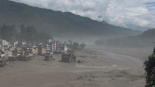 Banjir di Nepal (NEPAL-FLOODS) Partially submerged buildings along the riverbank due to a flash flood in Nuwakot district, Nepal, August 26, 2026, in this screen grab obtained from a handout video. Sujan Bagale/Handout via REUTERS THIS IMAGE HAS BEEN SUPPLIED BY A THIRD PARTY. MANDATORY CREDIT. Verification lines: - Building structure, signage and topography match archive imagery. - Date and location was verified from original file metadata. - Rasuwa district administrator Narendra Pariyar urged those living on the banks of the Bhote Koshi river in the area to seek higher ground, pointing to reports that nearby villages and infrastructure project sites were washed away. TPX IMAGES OF THE DAY