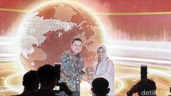 Dirut Telkom Dian Siswarini memberikan plakat penghargaan kepada Direktur Jenderal Ekosistem Digital Kementerian Komdigi Edwin Hidayat Abdullah. Foto: Adi FR/detikINET
