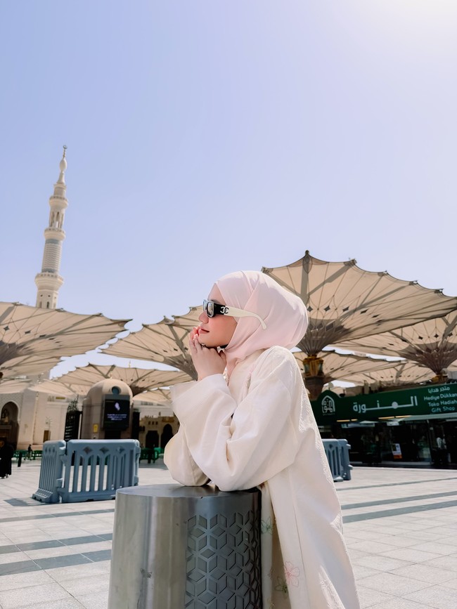 Penampilan Ummi Quary saat mengenakan outer model abaya dengan hijab bernuansa pink soft memikat perhatian dan menuai beragam pujian dari warganet. Banyak pengguna media sosial yang menyanjung gaya berbusananya karena dinilai sangat manis, santun, dan memancarkan pesona yang menyejukkan hati. MasyaAllah ummi cakep nya😍, puji akun @valvalzy_. Pake hijab cantik nya naik 1000 kali lipat 🔥👏, kagum akun @devian_amri83. Foto: Dok. Instagram @ummi_quary.