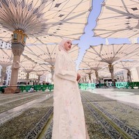 Ketika berada di halaman Masjid Nabawi, penampilannya menjadi sorotan saat memakai hijab pashmina instan simpel bernuansa pink soft yang membuat wajahnya terlihat cerah dan manis. Foto: Dok. Instagram @ummi_quary.