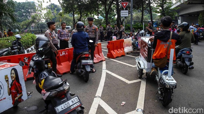 Petugas kepolisian melakukan pengalihan arus lalu lintas di kawasan Gedung DPR/MPR RI, Jakarta, Kamis (27/8/2026), menyusul berlangsungnya aksi penyampaian pendapat di sekitar kompleks parlemen.