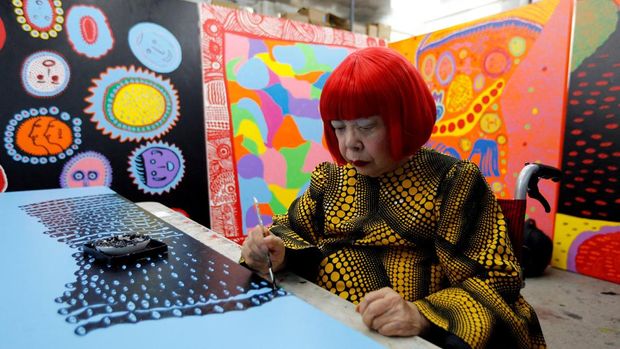 Seniman Yayoi Kusama berpose bersama detail karya seninya yang berjudul 
