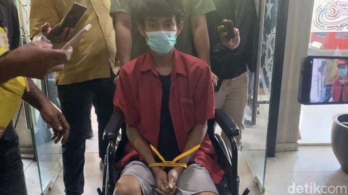 Tersangka saat dibawa pakai kursi roda (Mhd Ilham Pradilla/detikcom)